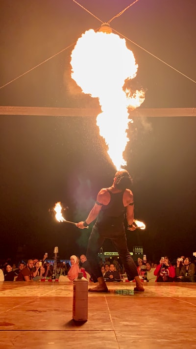 Man wearing a red vest and black shorts with orange flames
